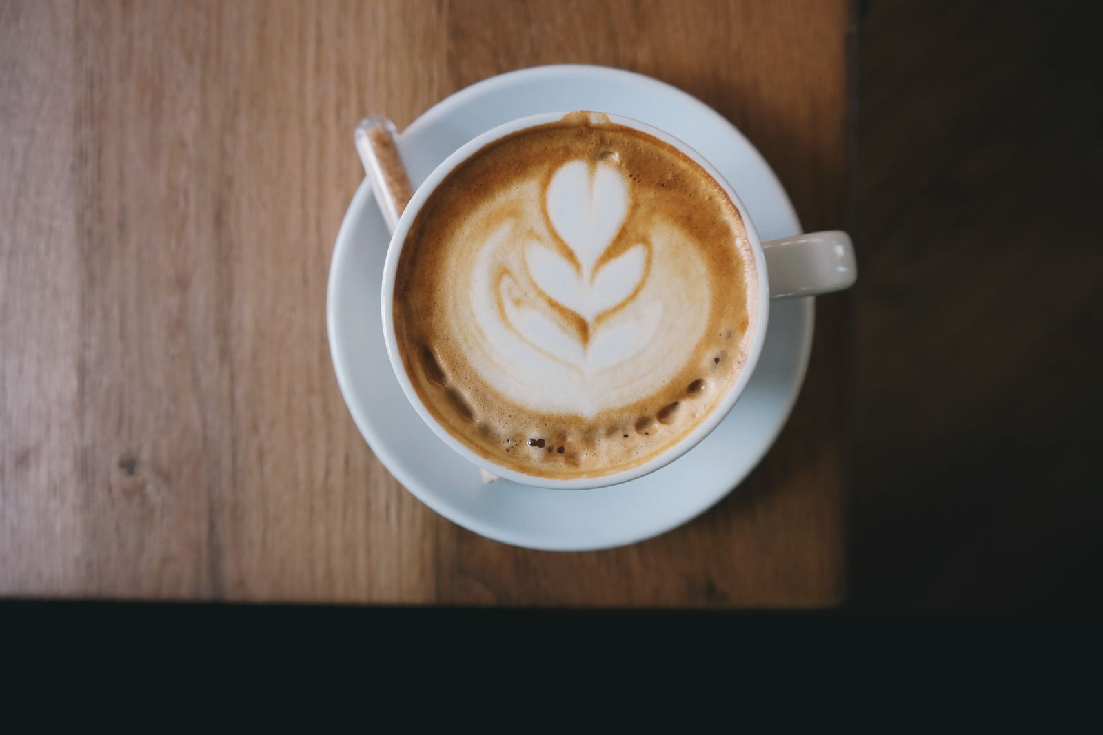 Cappuccino mit Latte-Art auf einem Holztisch